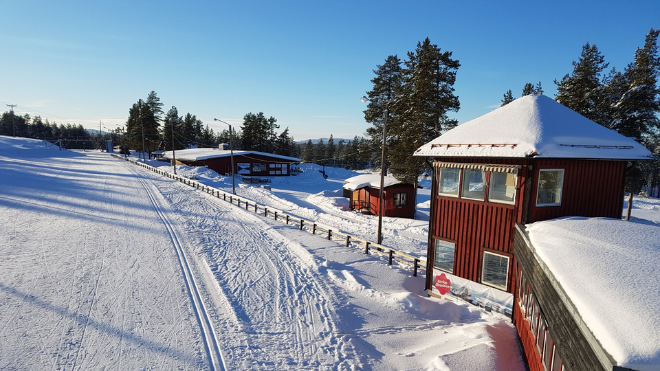 Skidspår och röda trähus på skidstadion i Sveg.