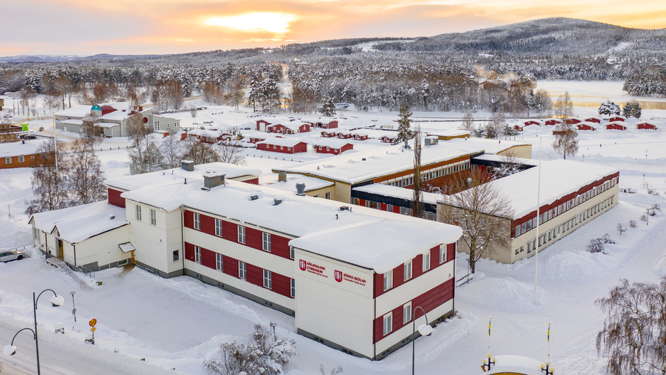 Drönar bild över skola i Sveg i vinterskrud.