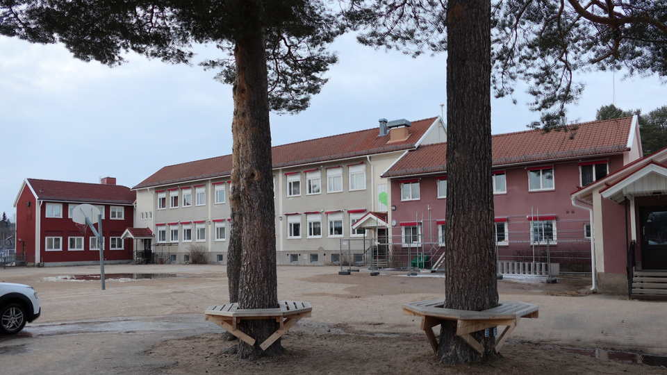 Skolbyggnader i två våningar med en skolgård framför